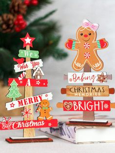 two wooden christmas trees with gingerbreads on top and merry signs in the middle