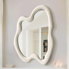 a mirror that is on the wall above a sink in a room with white walls