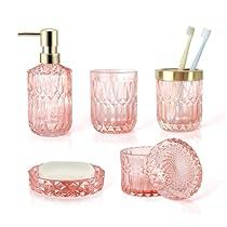 pink glass bathroom accessories including soap dispenser, toothbrush holder and soap dish