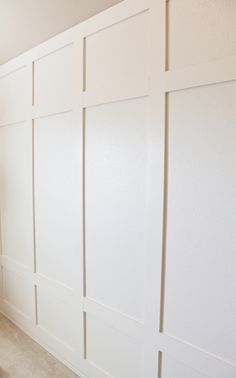 a bathroom with white walls and tile flooring next to a toilet in the corner