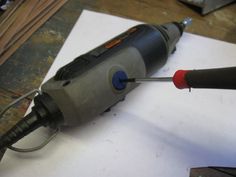 an electric drill is being used on a piece of paper