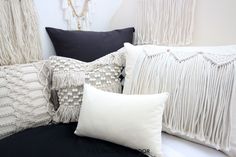 pillows are arranged on a couch with tassels