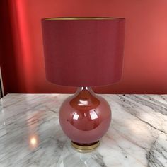 a pink lamp sitting on top of a marble table