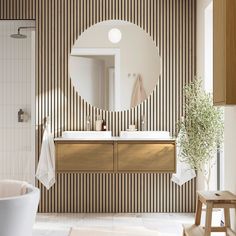 a white bath tub sitting next to a bathroom sink under a round mirror on a wall