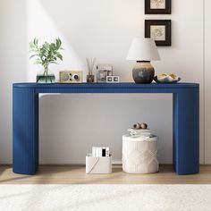 a blue console table sitting on top of a hard wood floor next to a lamp