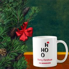 a white coffee mug sitting on top of a red tile floor next to a pine tree