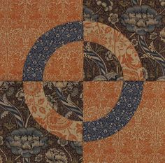 an orange and blue patchwork quilt with flowers on it's side, in the middle