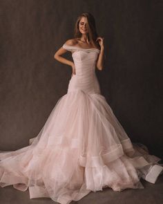 a woman in a wedding dress posing for the camera with her hands on her hips