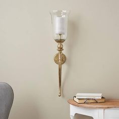 a wall light with a candle on it next to a chair