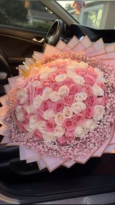 a bouquet of pink and white roses in the back of a car