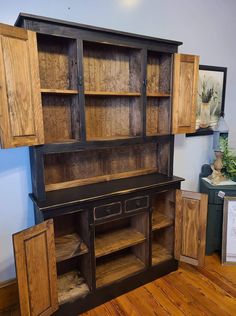 an old wooden hutch with drawers and cupboards on the floor in a room