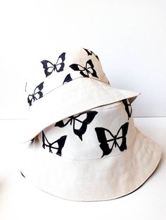 Flower Bucket Hat, white Bucket Hat, Handmade, Handpainted Fashionable and comfortable bucket hat, head accessory. Perfect for covering the face and eyes from sun All hats are painted by hand so there might be some ever-so-slight differences (maybe a thicker/thinner brush stroke in some spots) No screen printing or vinyl transfers, it's all made from the heart baby :) You can also combine your bucket hat with a trendy bag to create your own perfect lewk Note: baguette bag seen on this post can b Cream Adjustable Bucket Hat, White Bucket Hat For Beach, White Bucket Sun Hat For Vacation, White Summer Bucket Hat For Festivals, Artistic White Brimmed Hat, White Summer Festival Hat, White Artistic Short Brim Hat, Artistic White Hat With Short Brim, White Bucket Shape Sun Hat For Summer