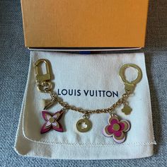 the louis vuitton charm bracelet is in its box and it has five charms