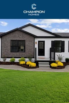 a white house with black shutters and yellow flowers in the front yard is featured for champion homes