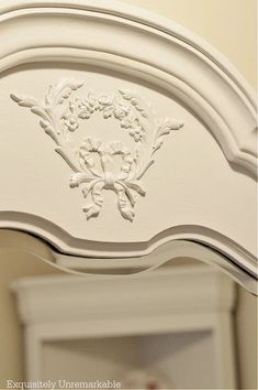 an ornately decorated white dresser with mirror