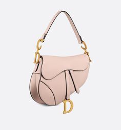 Maria Grazia Chiuri brings a fresh update to the iconic Saddle bag. Crafted in powder pink grained calfskin, the legendary design features a Saddle flap with a D stirrup strap and magnetic pull, as well as an antique gold-finish metal CD signature on either side of the handle. Equipped with a thin, adjustable and removable strap, the Saddle bag may be carried by hand, worn over the shoulder or crossbody.. Dior Star, Icon Shoes, Dior Book Tote, Maria Grazia Chiuri, Maria Grazia, Star Shoes, Wallet Pouch, Backpack Tote Bag, Silver Cufflinks