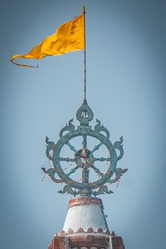 an ornate clock tower with a yellow flag on top