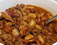 a white bowl filled with beans and meat