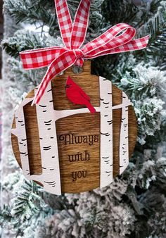 a wooden ornament hanging from a tree with a red bird on it's back