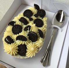 an oreo cookies and cream cake in a box with a spoon next to it