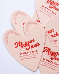 four heart shaped save the dates cards on a white background