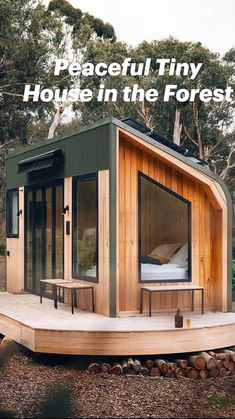 a small wooden cabin in the middle of some trees and rocks with a bed on top