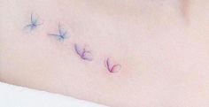 a woman's stomach with three small butterflies on the left side of her belly