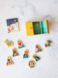 various wooden magnets are placed next to a book on a marble counter top,