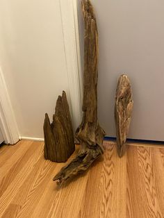 two pieces of driftwood sitting on the floor next to a door