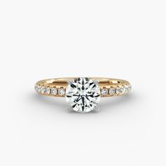 a diamond engagement ring with two rows of diamonds on the band and side stones in yellow gold