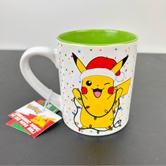 a mug with a pikachu on it and a christmas card next to it