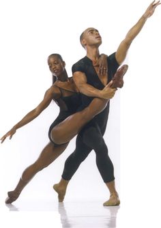 two ballerinas in black leotards, one holding the other