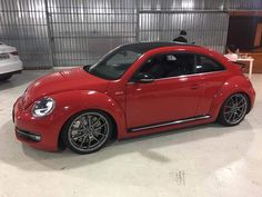 a red car parked in a garage next to other cars