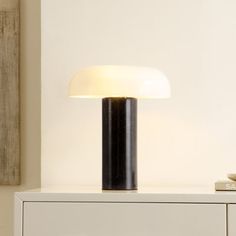 a lamp sitting on top of a white dresser