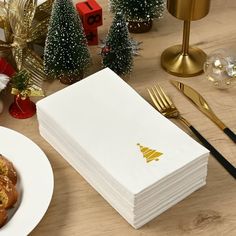 a stack of napkins sitting on top of a table next to a plate of food