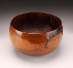 a wooden bowl sitting on top of a white table