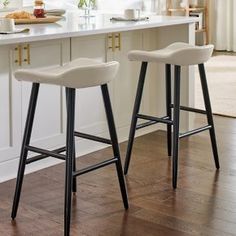 two bar stools sitting on top of a kitchen counter