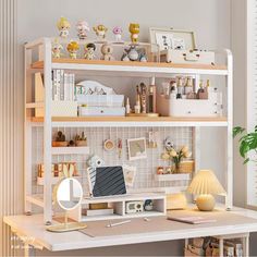 a white desk topped with a laptop computer next to a shelf filled with lots of clutter