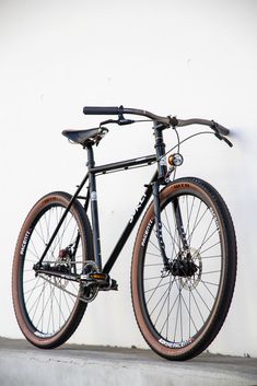 a bike leaning against a white wall with no wheels or spokes on the front wheel