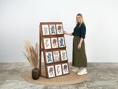 a woman standing in front of a wooden easel