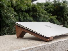 an apple laptop sitting on top of a stone slab