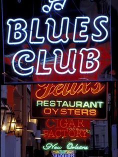 a neon sign that says blues club on the side of a building