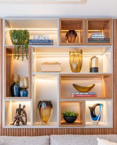 the shelves are filled with vases, books and other decorative items in varying shapes