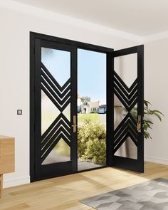 an open black double door in a white room with wood flooring and potted plant