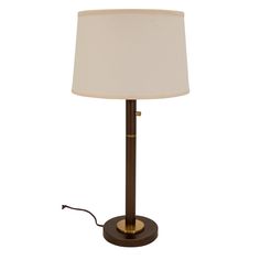 a table lamp with a white shade on the base and a brown metal frame around it