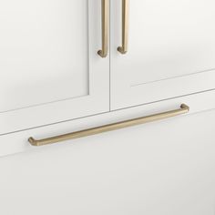 a white cabinet with two brass handles on it