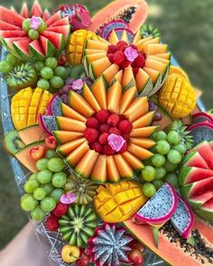 a bunch of fruit is arranged in the shape of a sunflower and watermelon