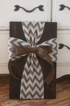 a gift wrapped in brown and white paper with a bow