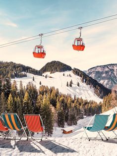 two ski lift chairs sitting on top of a snow covered slope