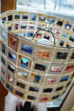 a lamp shade made out of photos is sitting on a window sill